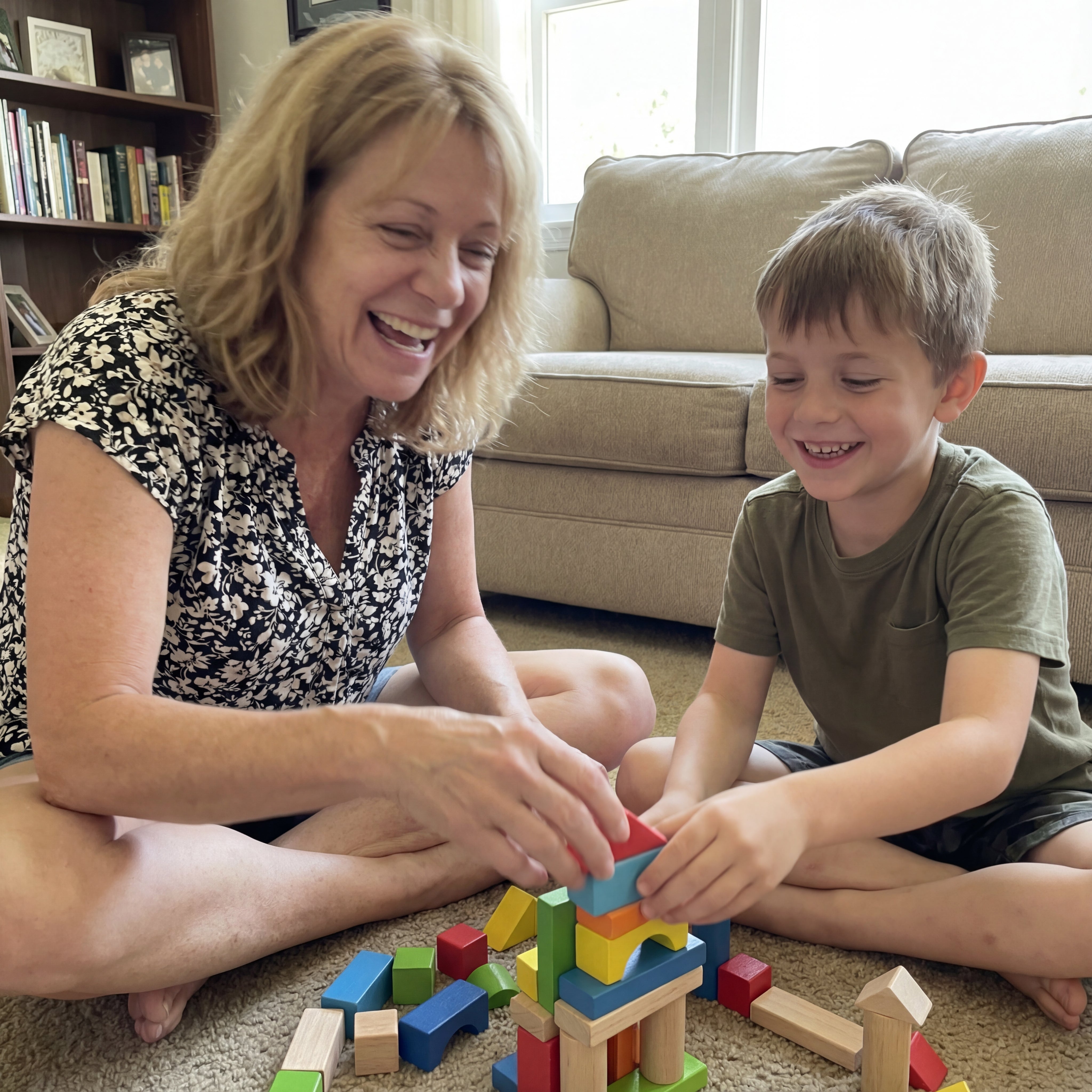 On the floor playing blocks with her grandson